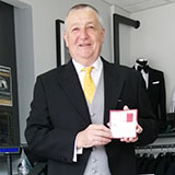 Photo of Tim Hewer with his British Empire Medal